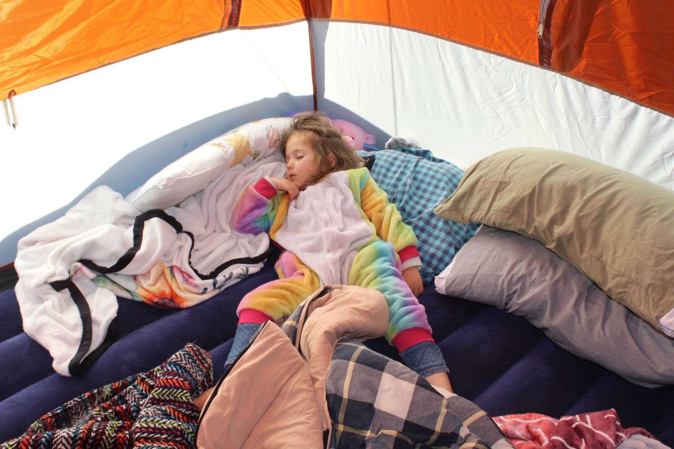 Little girl in unicorn onesie passed out in her tent at PlayThink